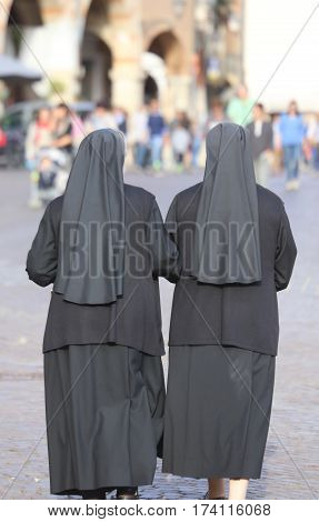 Two Nuns With Black Long Dresses And A Veil To Cover The Hair Th