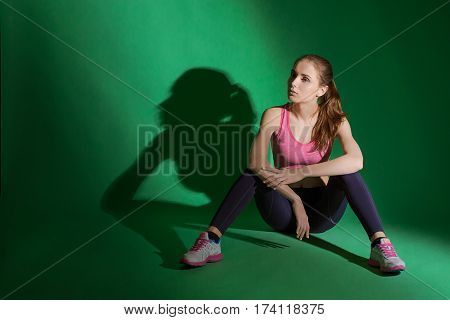 Healthy fit body of beautiful young caucasian woman sitting on the floor wearing sports wear