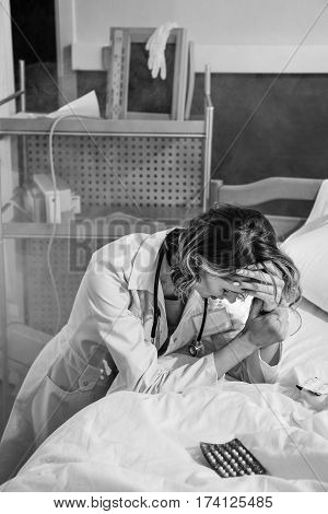 black and white photo of upset doctor in uniform in ruined hospital chamber
