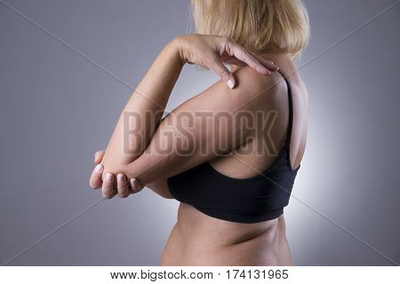 Pain in joint care of female hands ache in woman's body on gray background