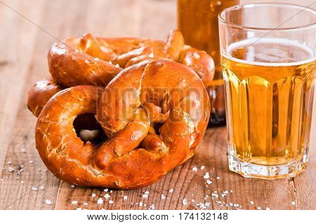 Bavarian pretzels with beer on wooden table.