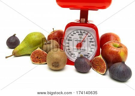 kitchen scales and ripe fruits on white background. horizontal photo.