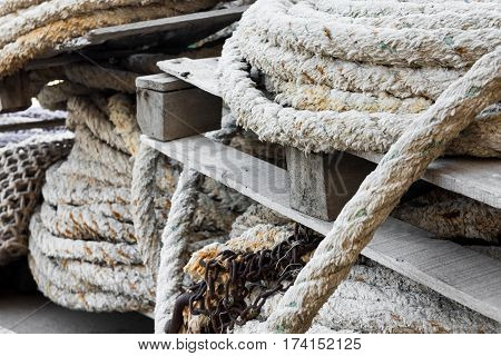Stack of rolled mooring ropes on timber pallets in a fishing port close up Mediterranean sea Costa Blanca Spain closeup