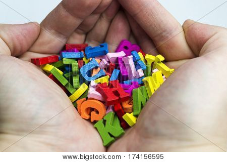 Hands holding a lot of letters on a white background.