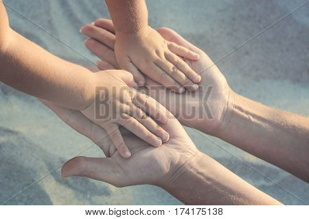 Mother and small baby play with sand. Baby hold her hands to the mothers arms. Active parents and people outdoor activity on summer vacations with children.