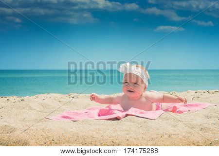Cure baby laying on the sunbed at the beach of Black sea
