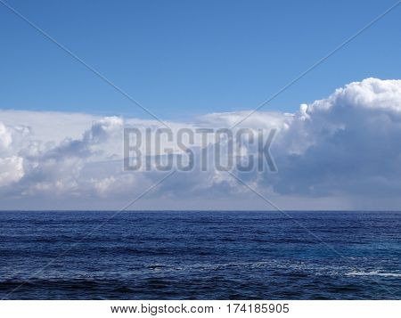 Shallow ocean waters of Windward side of Oahu looking into the pacific ocean and clouds.