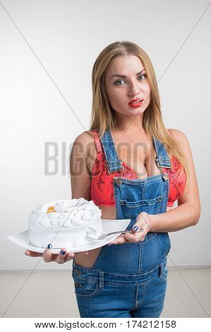 Busty sexy girl eating cake with whipped cream. white background