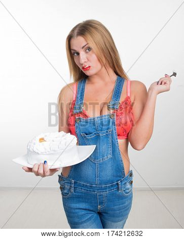 Busty sexy girl eating cake with whipped cream. white background