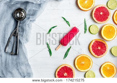 fresh citrus slices with fruit popsicles on stone table background top view