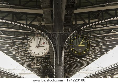 Old and new clock next to each other on the platform of the train station Picture of an old and a new clock next to each other indicating the same time