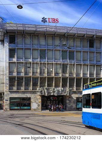 Zurich, Switzerland - 14 May, 2015: people at the entrance to the UBS office on Talacker street, a tram passing, view from Paradeplatz square. UBS AG is a Swiss global financial services company.
