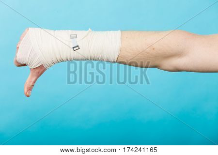 Bad news and information. Medicine aspects. Male hand with bandage showing thumb down sign symbol.