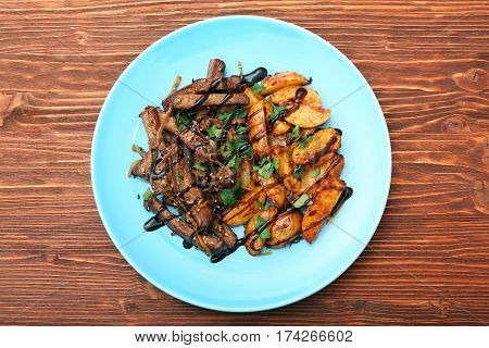Homemade Slow Cooked Beef with Potatoes on wooden background