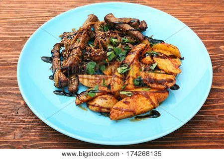 Homemade Slow Cooked Beef with Potatoes on wooden background