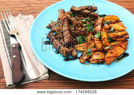 Homemade Slow Cooked Beef with Potatoes on wooden background