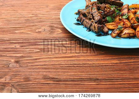 Homemade Slow Cooked Beef with Potatoes on wooden background