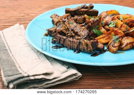 Homemade Slow Cooked Beef with Potatoes on wooden background