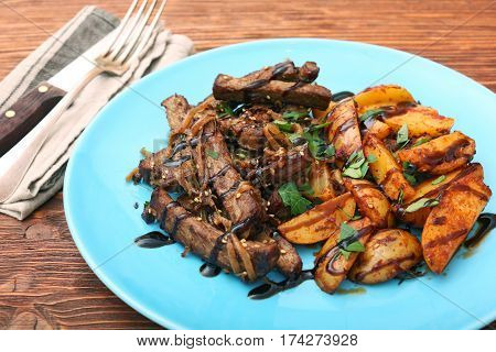 Homemade Slow Cooked Beef with Potatoes on wooden background