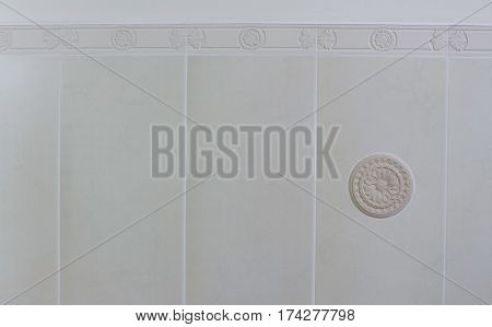 Decor element from plaster on the white tile background in the bathroom