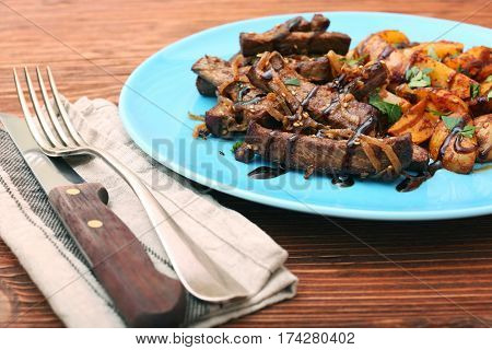 Homemade Slow Cooked Beef with Potatoes on wooden background
