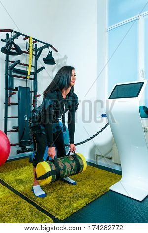 The female athlete doing they exercise in the EMS fitness studio