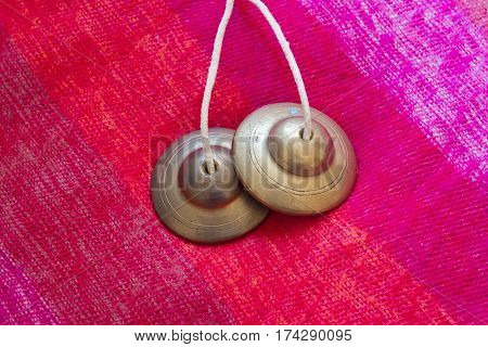 tibetan bell tingsha on pink wool .