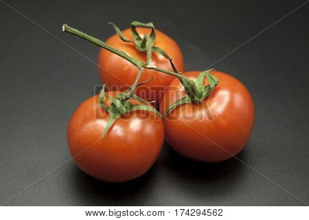 Ripe tomatoes on black background.