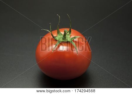 Ripe tomatoes on black background.