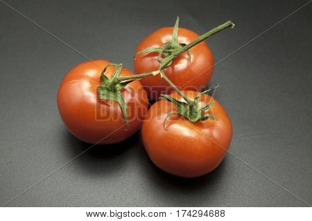 Ripe tomatoes on black background.