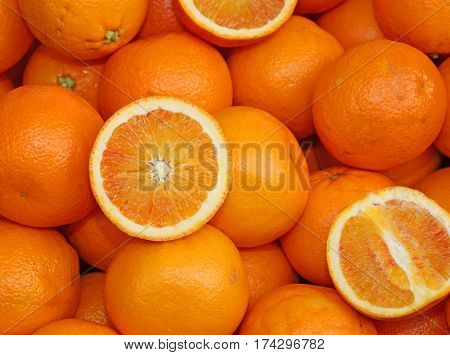 Ripe Oranges And An Orange Cut In The Stall Of Greengrocer