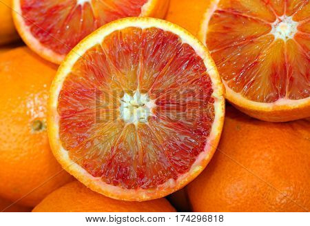 Oranges And An Orange Cut In The Stall Of Greengrocer