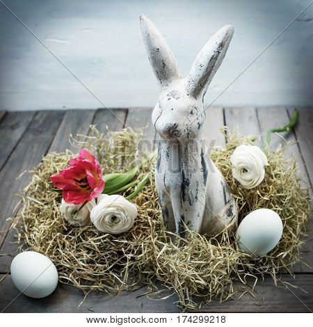Easter nest with eggs and a bunny in shabby chic style on a wooden table