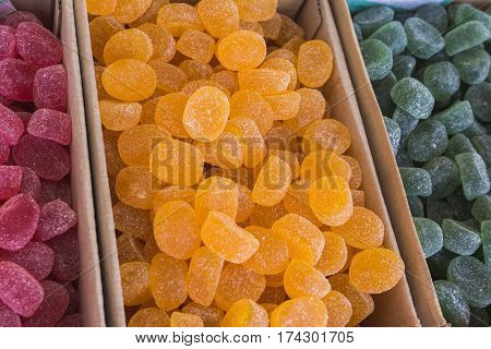 Yellow marmalade with the icing sugar at street market, top view