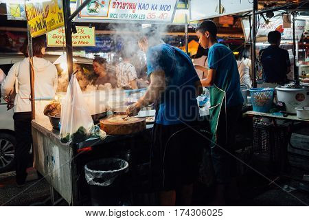 CHIANG MAI THAILAND - AUGUST 27: Father and sun cooking food at the Saturday Night Market on August 27 2016 in Chiang Mai Thailand.