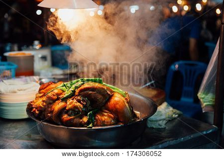Hot pork cools down at the Saturday Night Market stall in Chiang Mai Thailand.