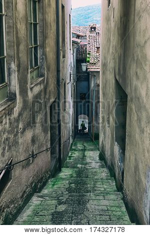Pedestrian is walking on the stairs of the narrow streets between the houses in a small Italian town