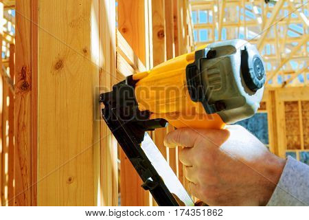 Framing contractor worker working on a small wall on a new commercial residential development New building home, nailing the air