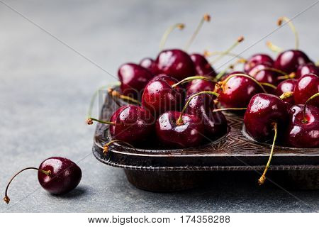 Black Cherries In Vintage Dish. Stone Background.