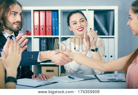 Male and female handshake in office. Serious business and partnership concept. Partners made deal sealed with handclasp.