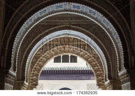 GRANADA SPAIN - FEBRUARY 10 2015: A close-up view to calligraphy decorated details of an archway at palace of Alhambra Granada Andalusia Spain.