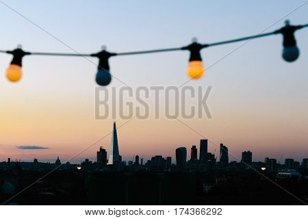 LONDON, UK - AUGUST 30, 2016: View of London skyline silhouette from an outdoor cinema party at Bussey Building Rooftop, Peckham, during sunset.