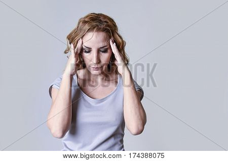 blond attractive woman on her thirties sad and depressed looking desperate in sorrow and grief facial expression in female depression emotion concept isolated on grey background
