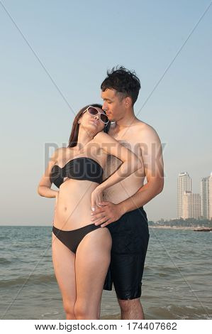 Lovely young adult couple standing on the beach.
