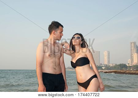 Lovely young adult couple standing on the beach.