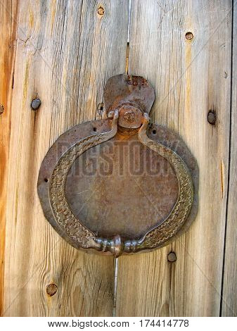 An old handle (old  ring) on the wooden gate. Closeup. Log hut in Siberian village. Lake Baikal, Russia