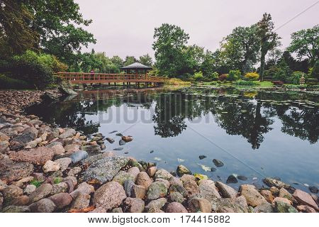 Japanese garden in Wroclaw, Lower Silesia, Poland. Natural park view with little japan pagoda, wooden bridge and small pond.