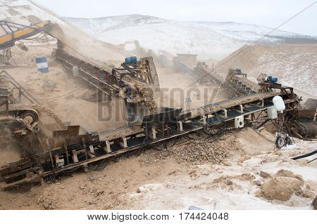 Conveyor belt of heavy machinery loads stones and gravel