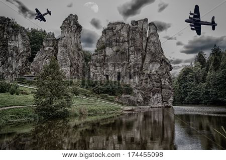 Two old combat aircraft bomber from the World War II flying over the Externsteine. Rock formation in the Teutoburg Forest Germany North Rhine Westphalia.
