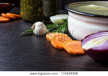 Soup with sorrel vegetables and boiled egg red onion carrots garlic dill on dark wooden table